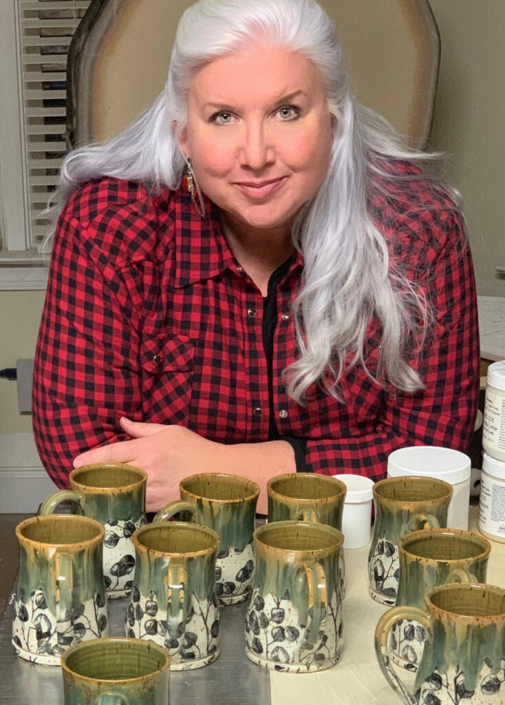 Suzanne Kleese-Stamps posing with her pottery.