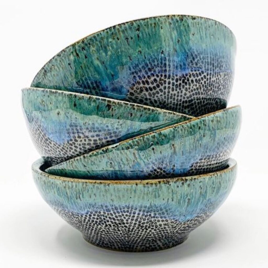 This set of bowls features a cascading blue glaze that beautifully transitions into a speckled pattern, creating a visual effect reminiscent of ocean waves meeting the shore. The artisanal glaze technique gives each bowl a unique character, perfect for a stylish table setting.